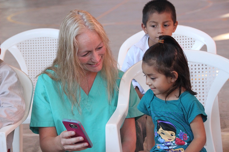 Dental team member showing two young children her phone