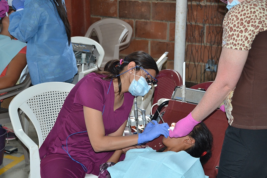 Two dental team members examining young patient