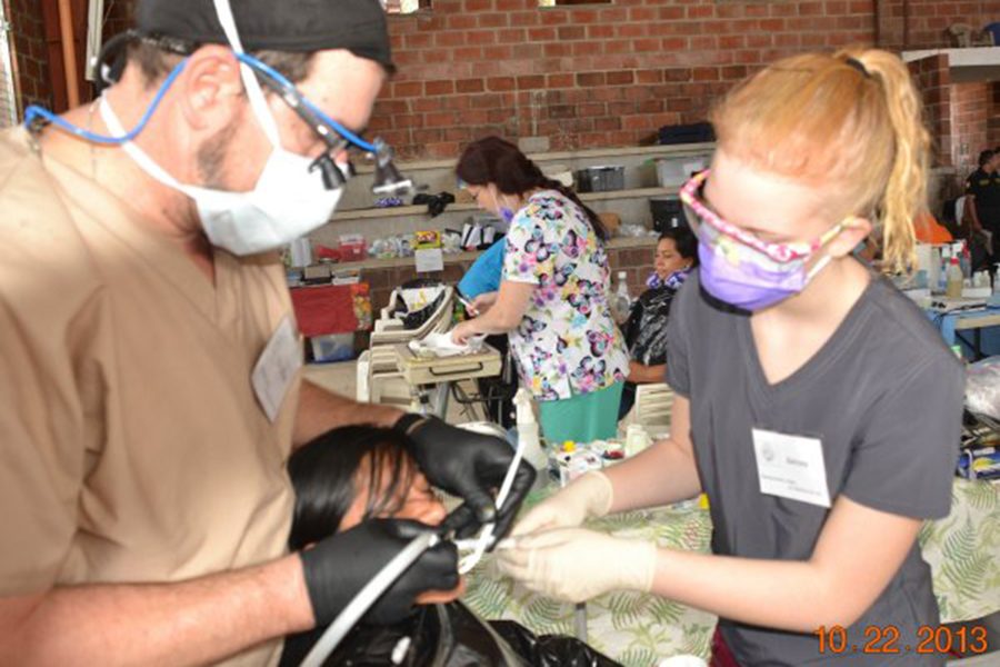 Dentist and dental team member treating relaxed dental patient