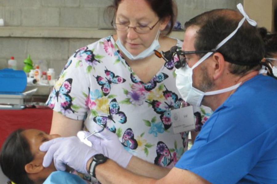 Dentit and team member examining dental patient