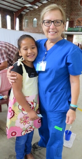 Dental team member smiling with young dental patient