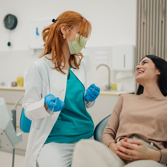 Smiling patient and dentist talking in treatment room