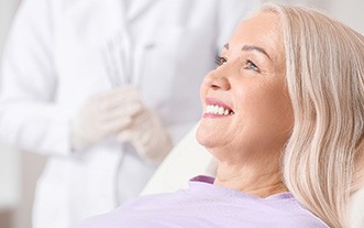 woman smiling while sitting in dental chair