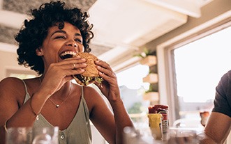 Woman smiling while eating lunch at restaurant